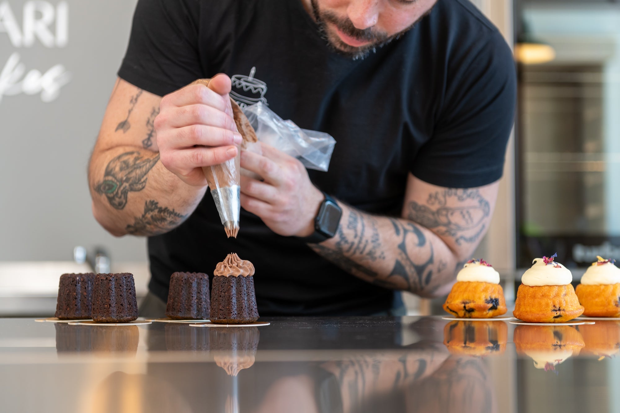 Guests decorating mini cakes with ganache and garnishes at Dhi Ferrari Cakes inside The Welder, Christchurch
