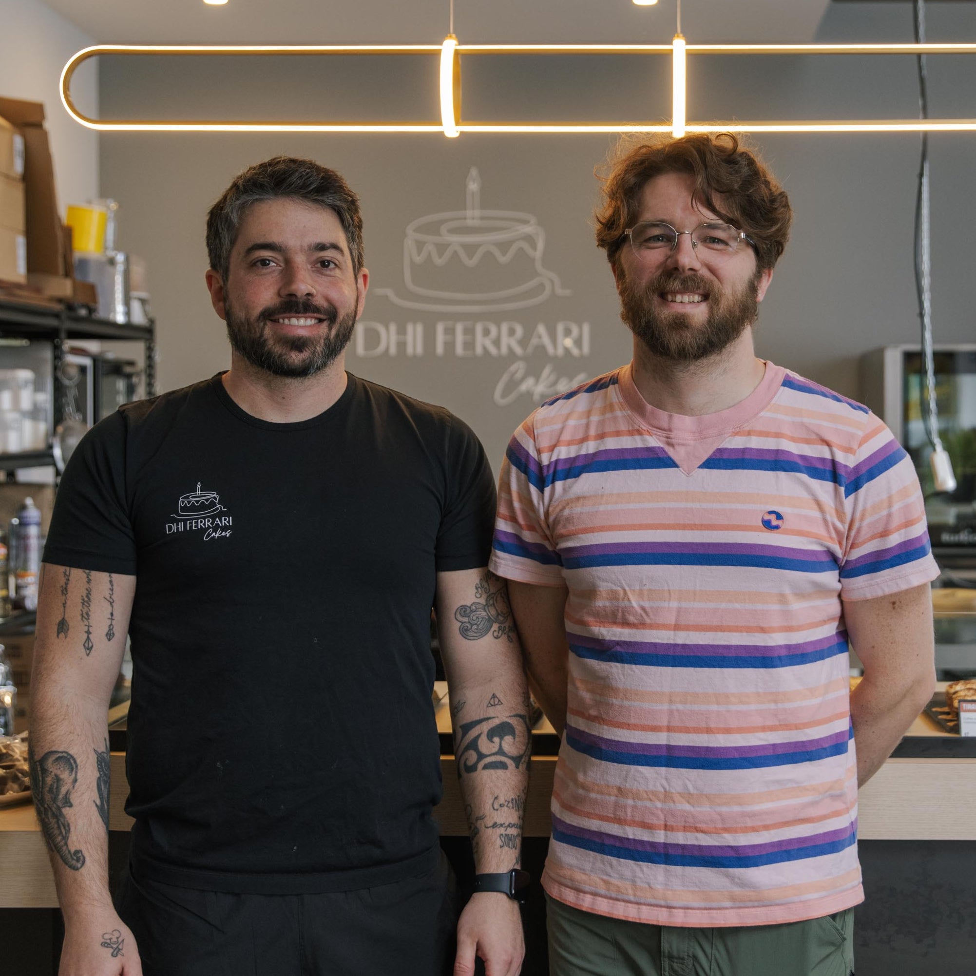 Two men standing in a kitchen or food preparation area.